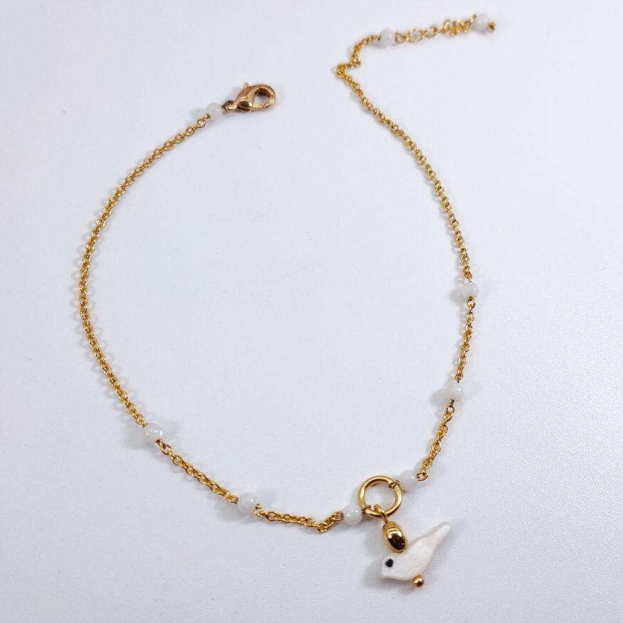 Chevillère perles denacre avec oiseau sur chaine acier inox doré
