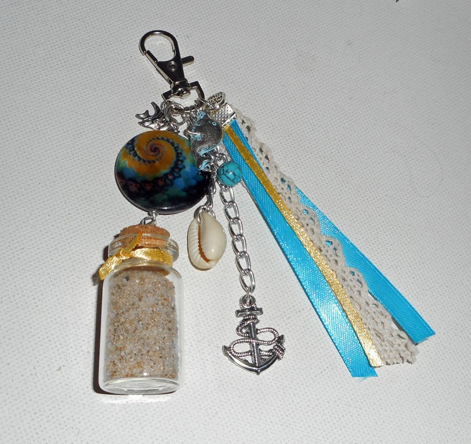 Porte clés/Bijoux de sac palet de nacre bleu jaune avec bouteille de sable et coquillage