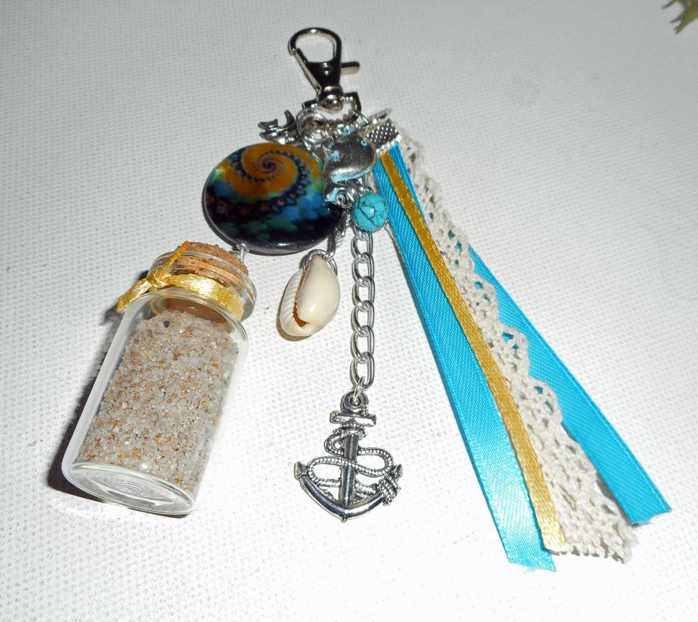Porte clés/Bijoux de sac palet de nacre bleu jaune avec bouteille de sable et coquillage